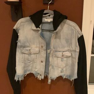 Light denim jean jacket with black sleeves and black hood. Small